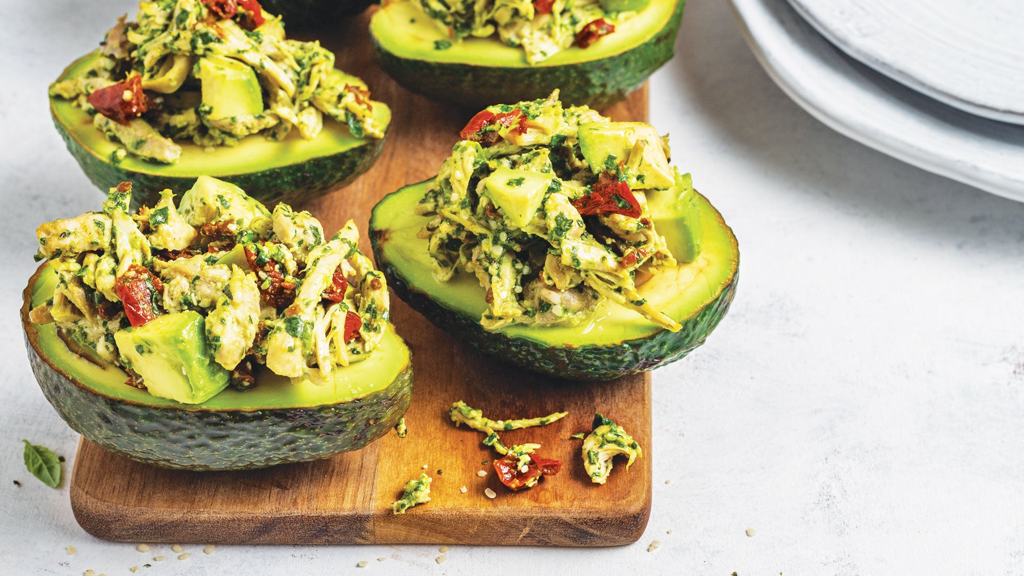 https://cdn.cleaneatingmag.com/wp-content/uploads/2019/12/pesto-chicken-salad-in-avocado-halves_90-web-1.jpg