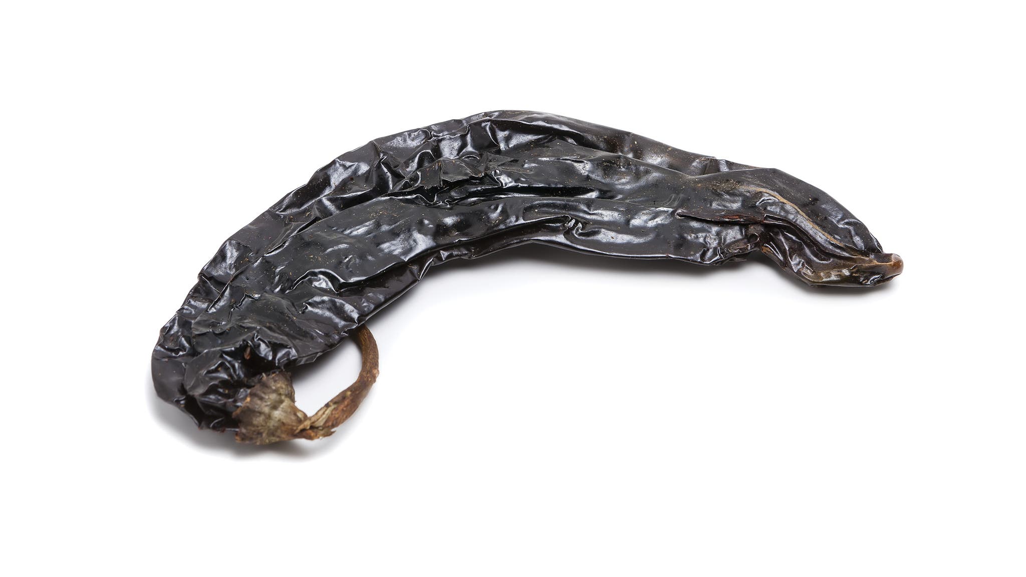 Dried pasilla chile on a white background