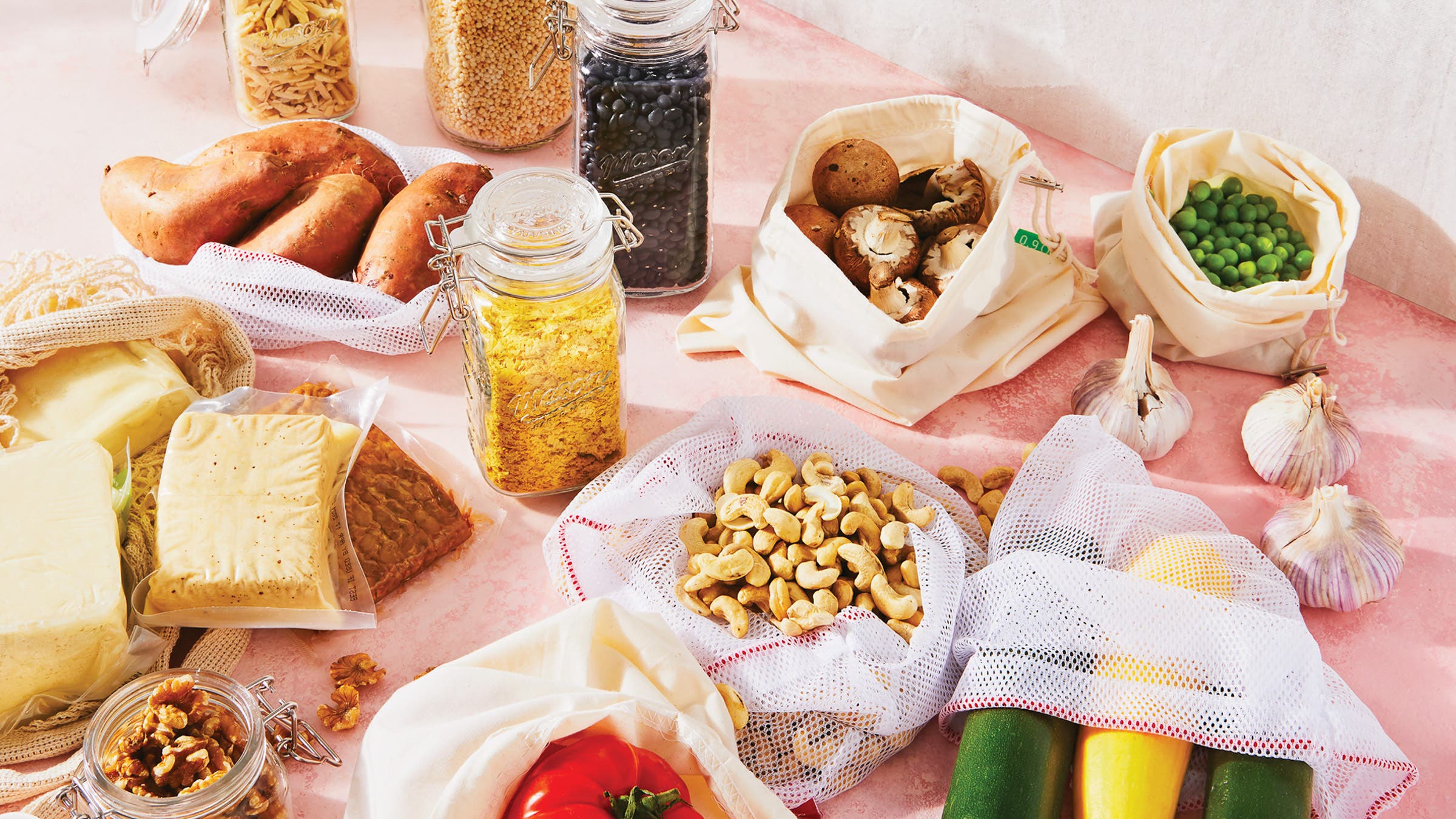 An assortment of plant-based proteins on a pink table