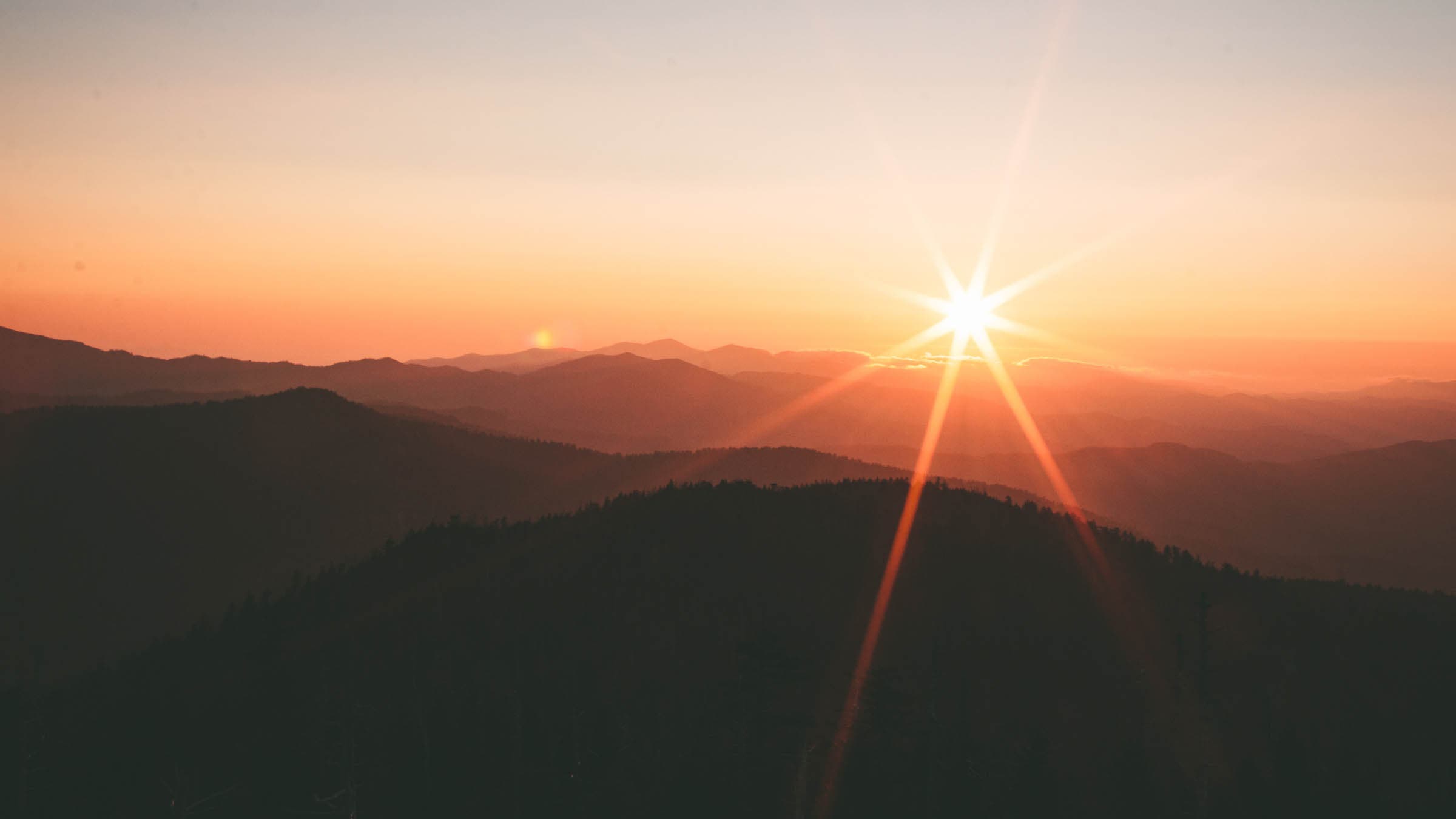 Sunset over a dark mountain range