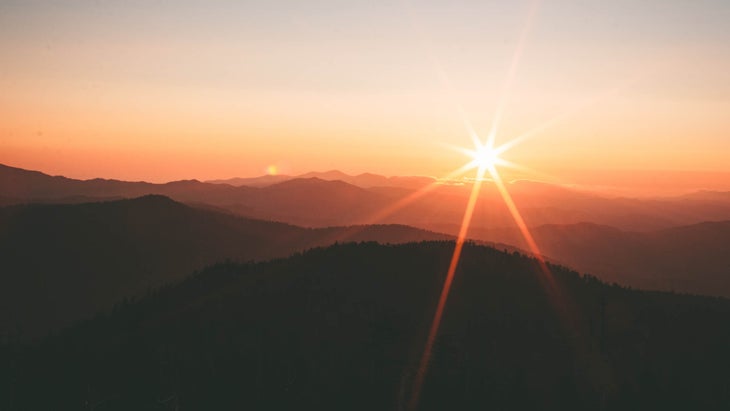 Sunset over a dark mountain range